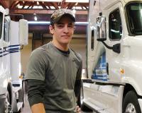 man between two white trucks